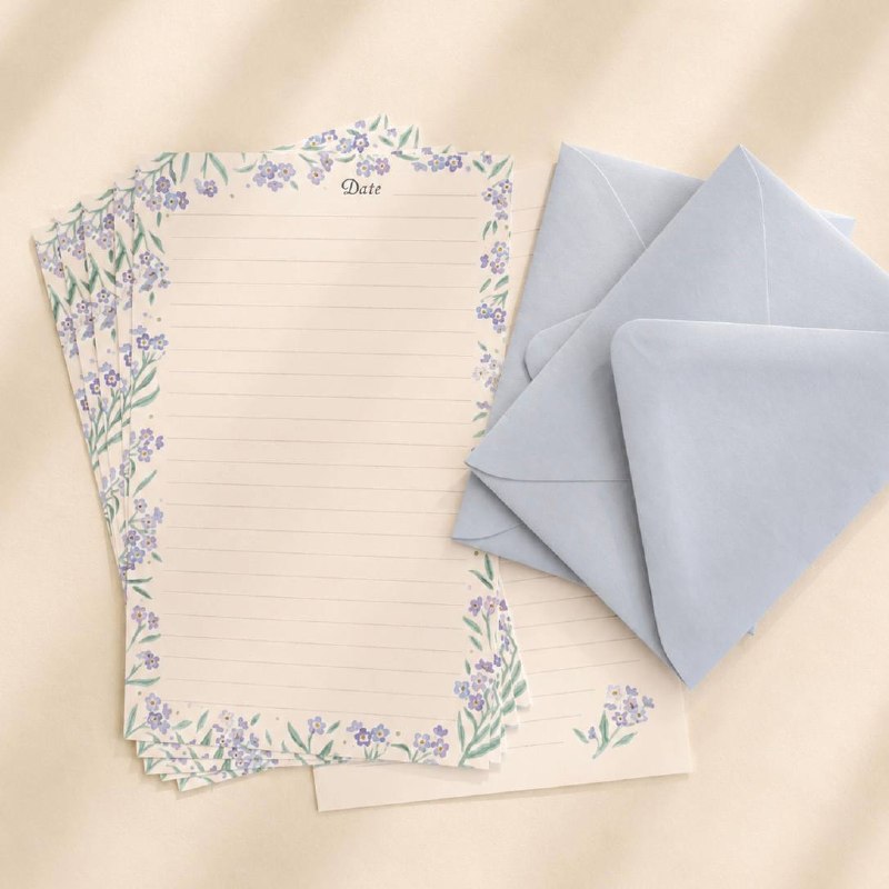 Forget-me-not writing sheets beside two powder-blue envelopes