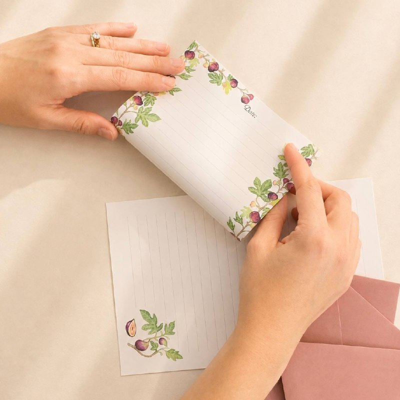 Hands folding a fig-patterned letter